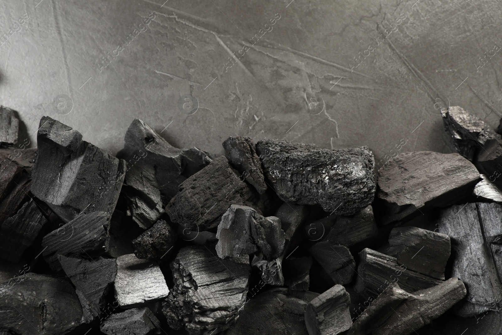 Pieces of black coals on grey table, flat lay. Space for text Photo of Pieces of black coals on grey table, flat lay. Space for text