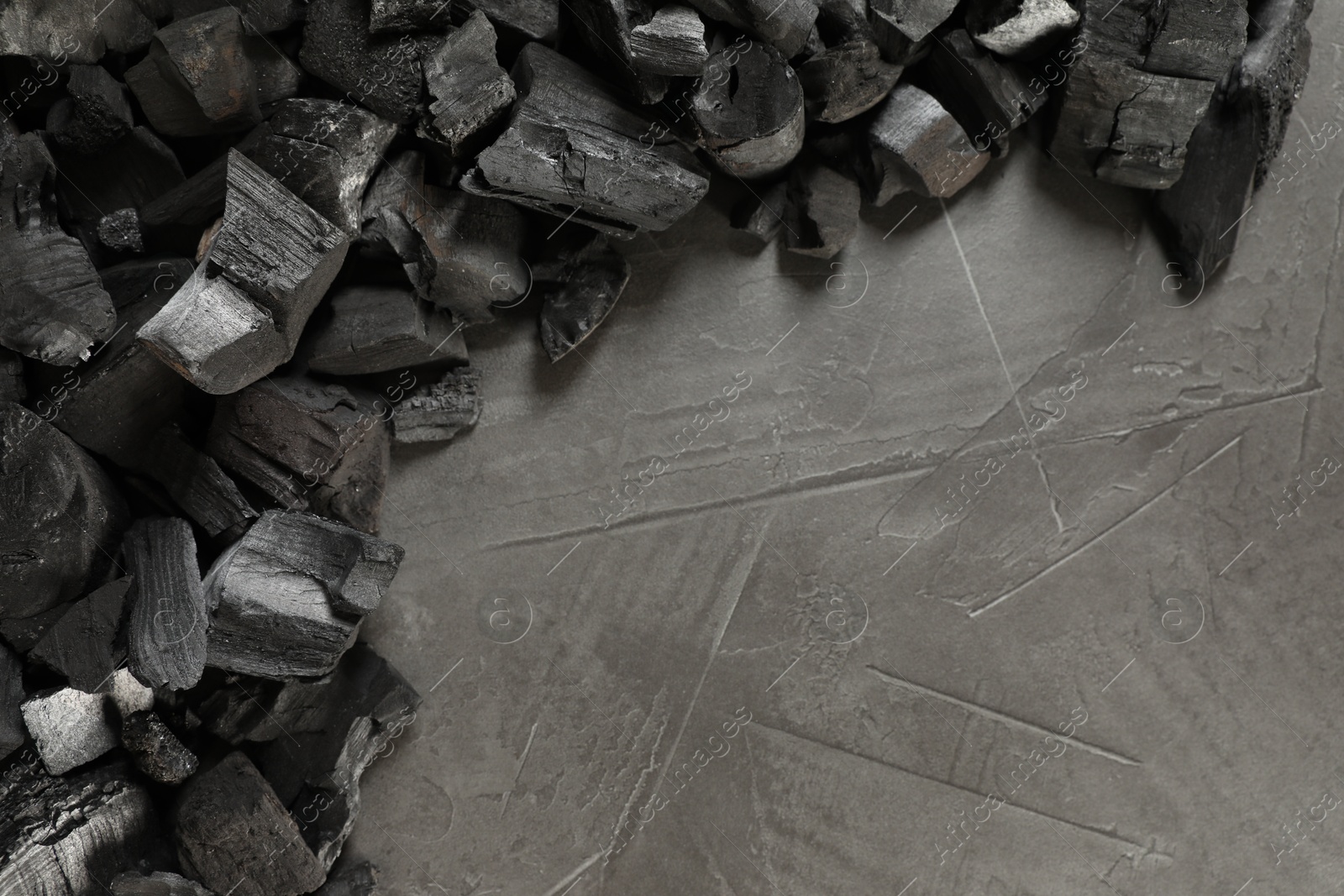 Pieces of black coals on grey table, flat lay. Space for text Photo of Pieces of black coals on grey table, flat lay. Space for text