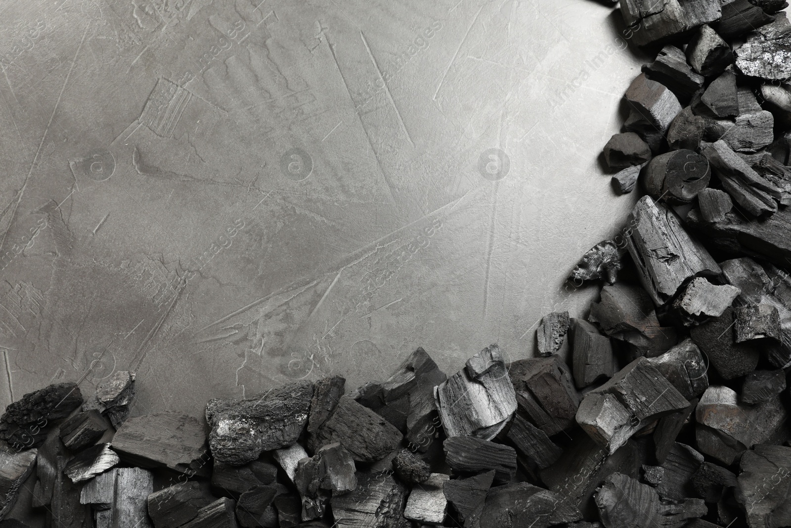 Pieces of black coals on grey table, flat lay. Space for text Photo of Pieces of black coals on grey table, flat lay. Space for text