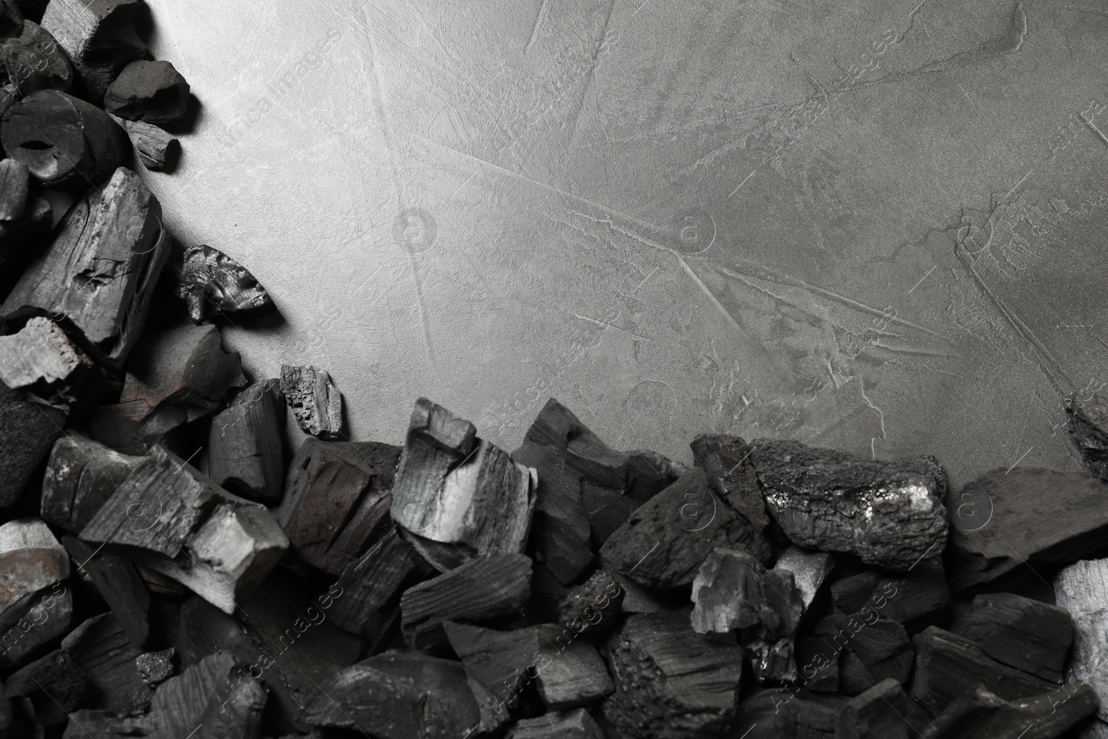 Pieces of black coals on grey table, flat lay. Space for text Photo of Pieces of black coals on grey table, flat lay. Space for text