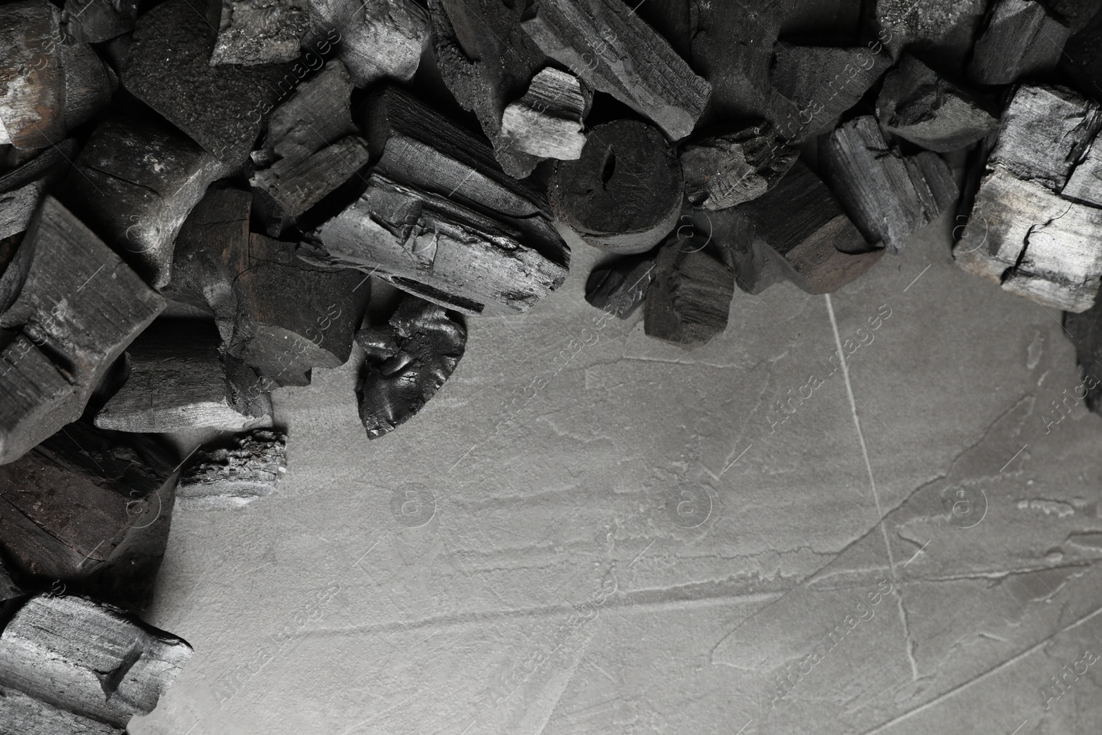 Pieces of black coals on grey table, flat lay. Space for text Photo of Pieces of black coals on grey table, flat lay. Space for text