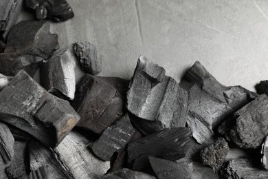 Photo of Pieces of black coals on grey table, flat lay