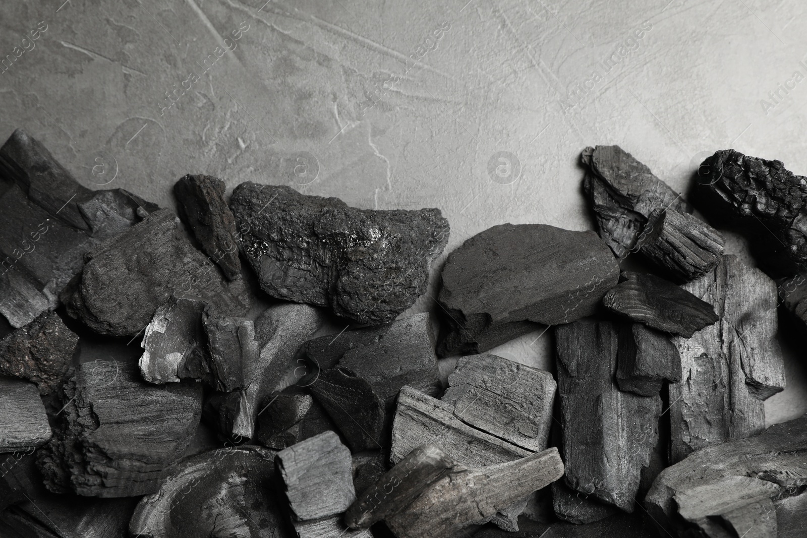Pieces of black coals on grey table, flat lay Photo of Pieces of black coals on grey table, flat lay
