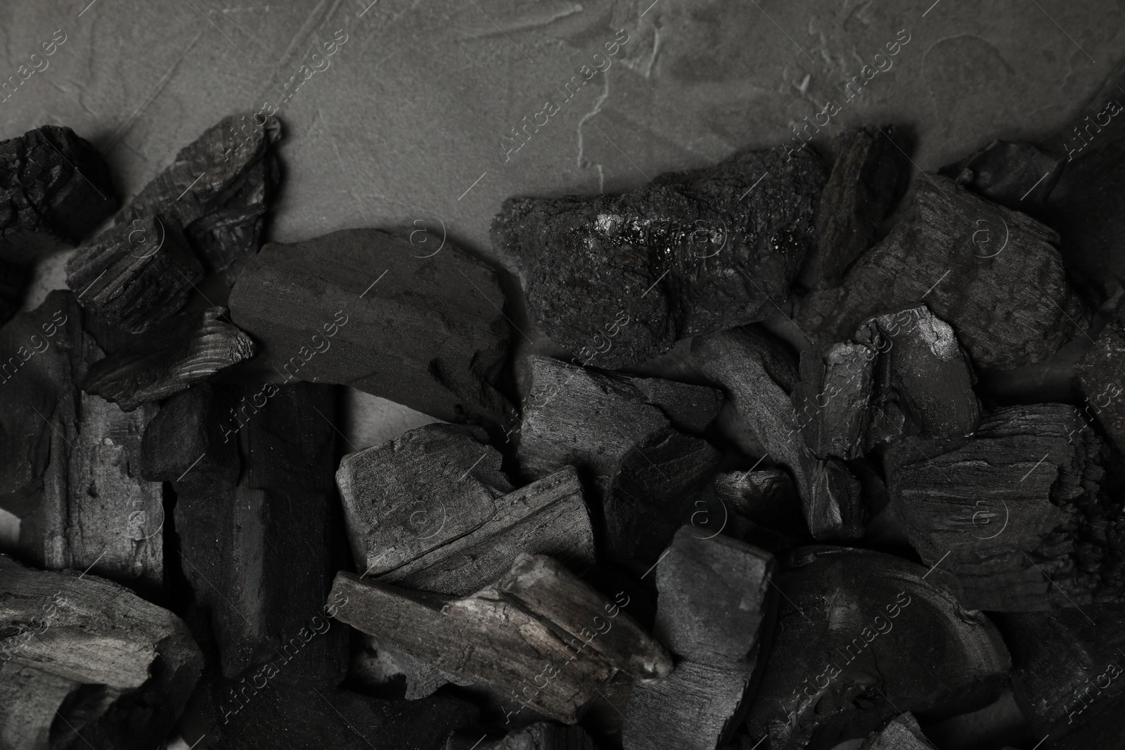 Pieces of black coals on grey table, flat lay Photo of Pieces of black coals on grey table, flat lay