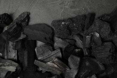 Photo of Pieces of black coals on grey table, flat lay