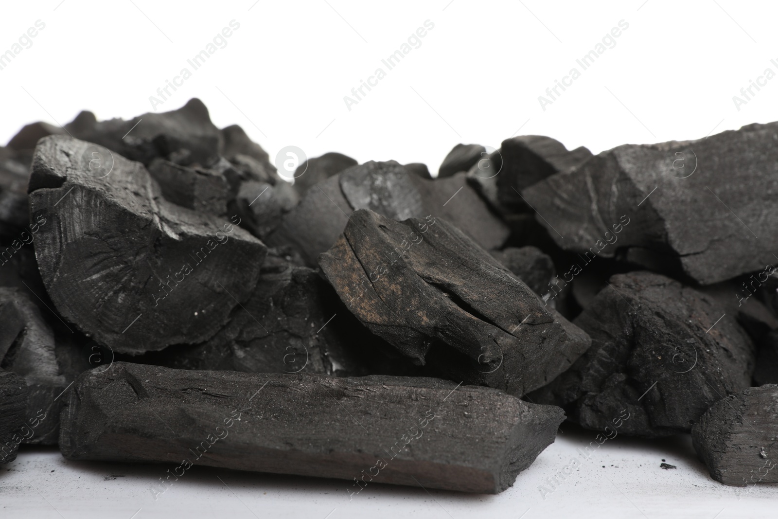 Pieces of black coals on white background Photo of Pieces of black coals on white background