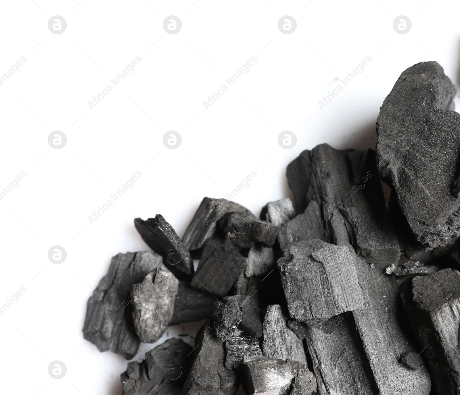 Pieces of black coals on white background, top view Photo of Pieces of black coals on white background, top view