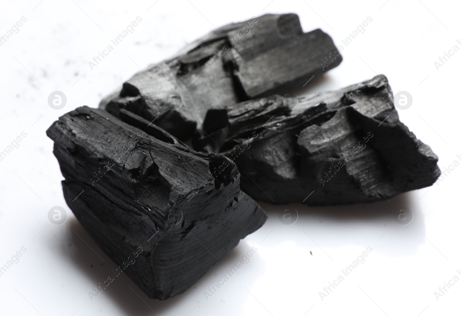 Pieces of black coals on white background Photo of Pieces of black coals on white background