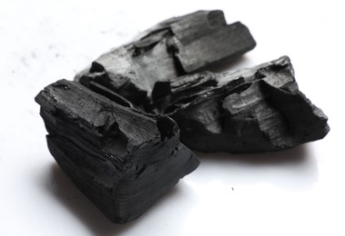 Photo of Pieces of black coals on white background