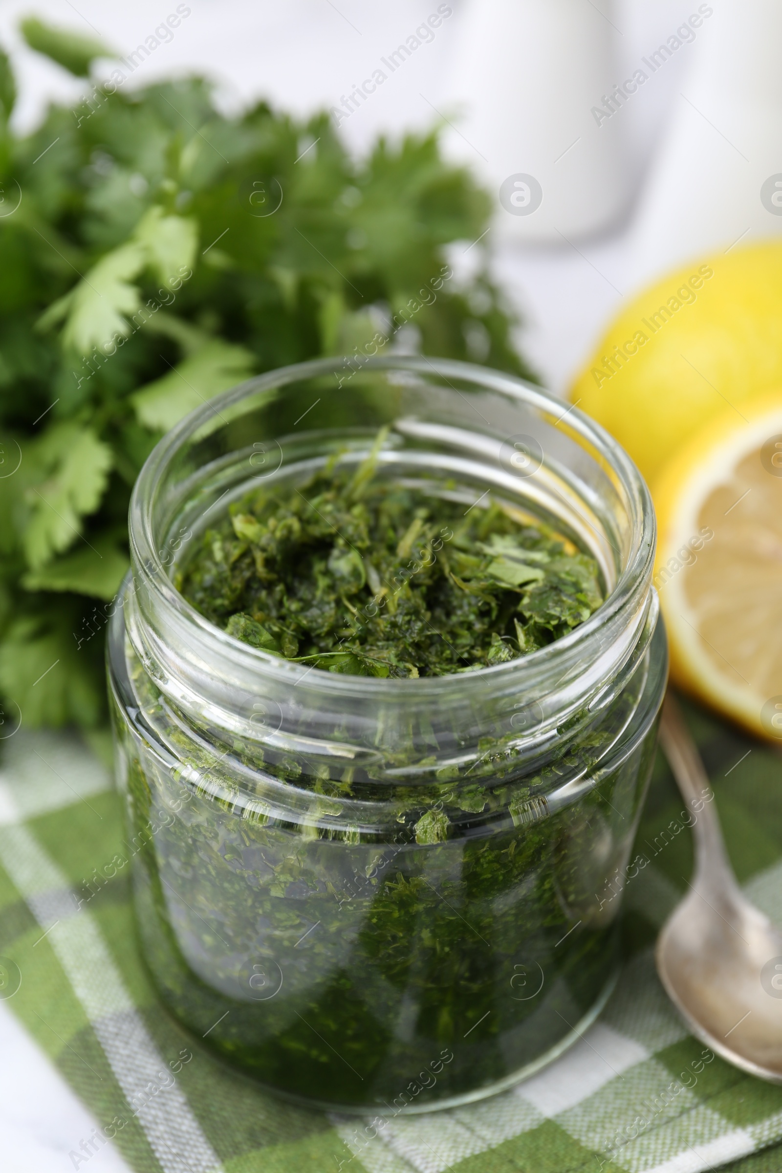 Tasty sauce with cilantro and lemons on table, closeup Photo of Tasty sauce with cilantro and lemons on table, closeup