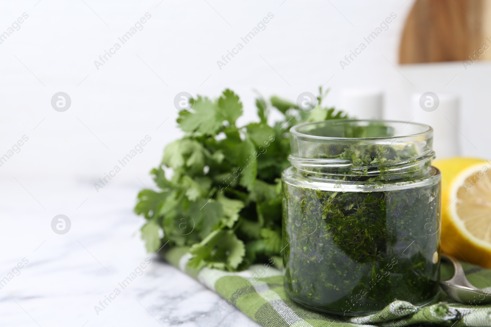 Tasty sauce with cilantro and lemon on white marble table, closeup. Space for text Photo of Tasty sauce with cilantro and lemon on white marble table, closeup. Space for text