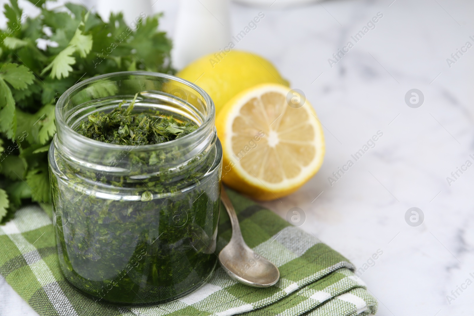Tasty sauce with cilantro and lemons on white marble table, closeup. Space for text Photo of Tasty sauce with cilantro and lemons on white marble table, closeup. Space for text