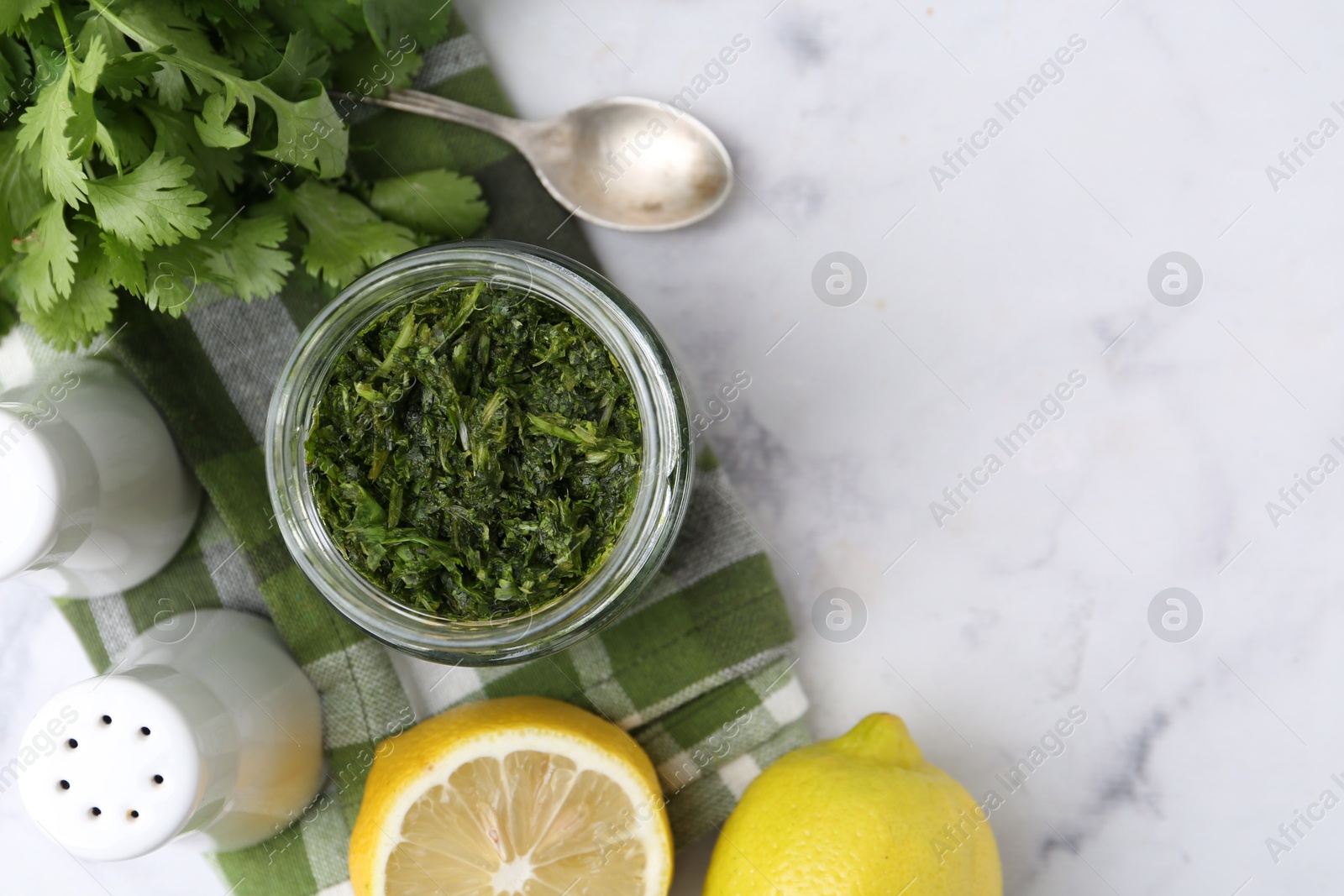 Tasty sauce with cilantro and lemons on white marble table, flat lay. Space for text Photo of Tasty sauce with cilantro and lemons on white marble table, flat lay. Space for text