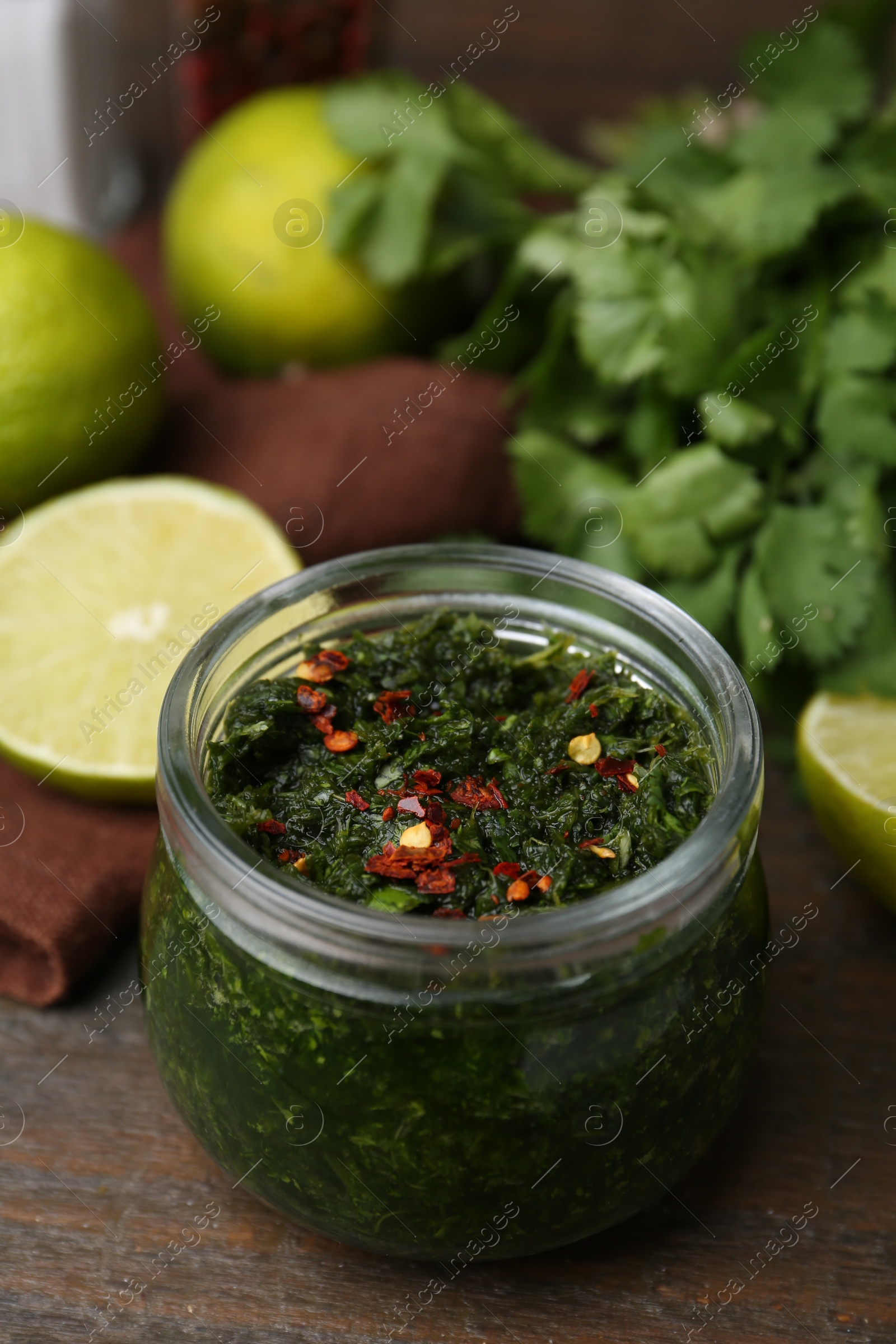 Tasty sauce with cilantro and limes on wooden table, closeup Photo of Tasty sauce with cilantro and limes on wooden table, closeup