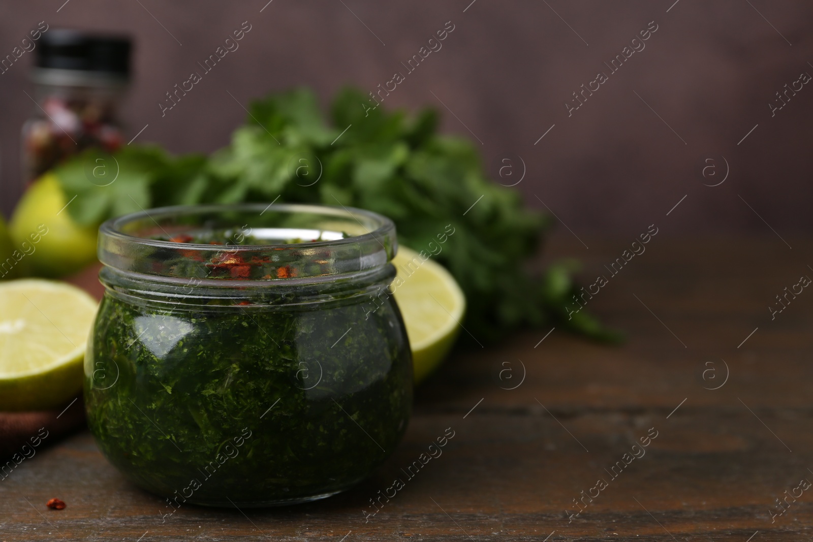 Tasty sauce with cilantro and limes on wooden table, closeup. Space for text Photo of Tasty sauce with cilantro and limes on wooden table, closeup. Space for text