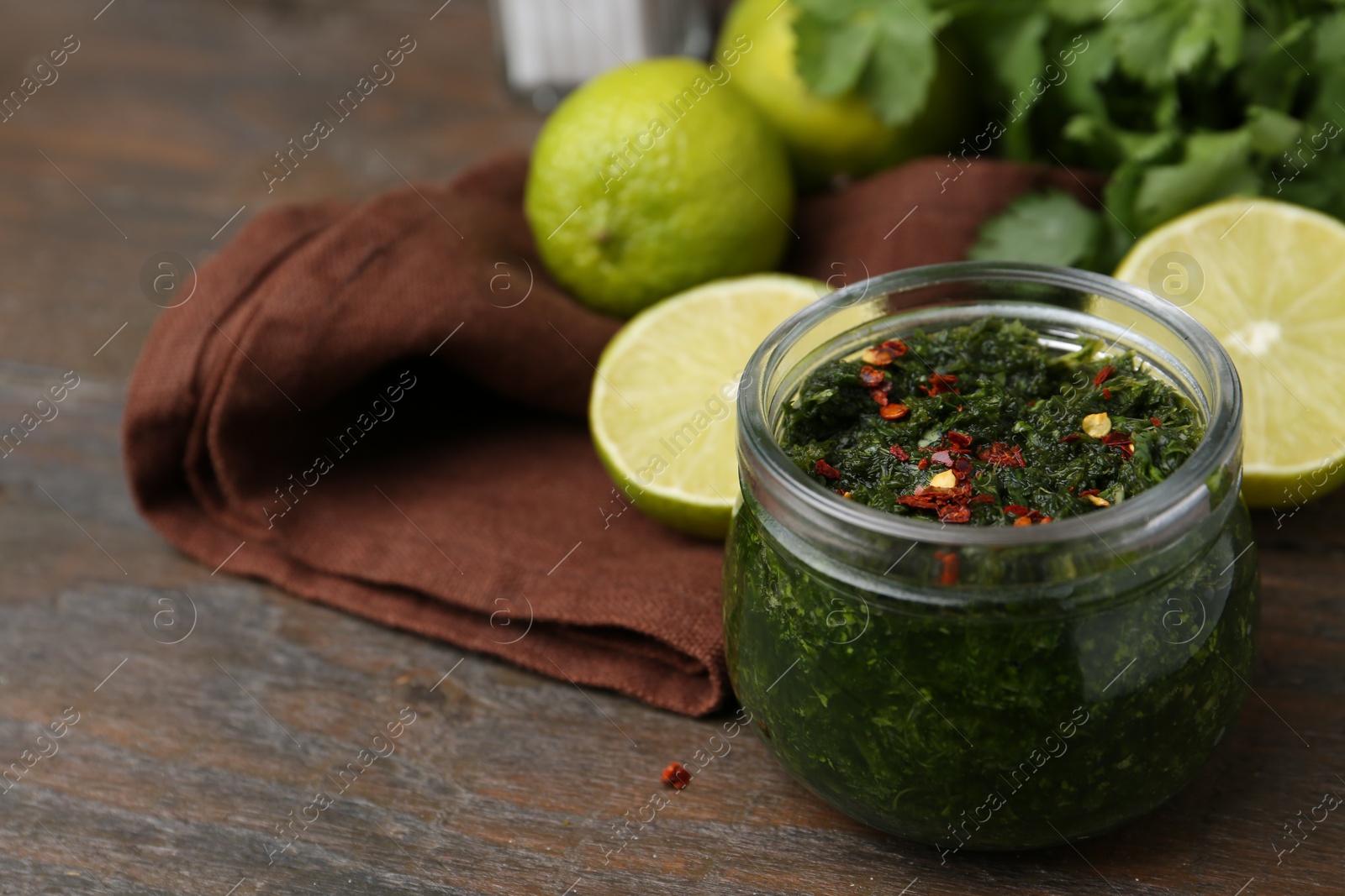 Tasty sauce with cilantro and limes on wooden table, closeup. Space for text Photo of Tasty sauce with cilantro and limes on wooden table, closeup. Space for text