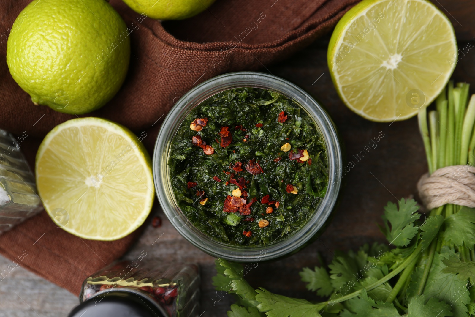 Tasty sauce with cilantro and limes on wooden table, flat lay Photo of Tasty sauce with cilantro and limes on wooden table, flat lay