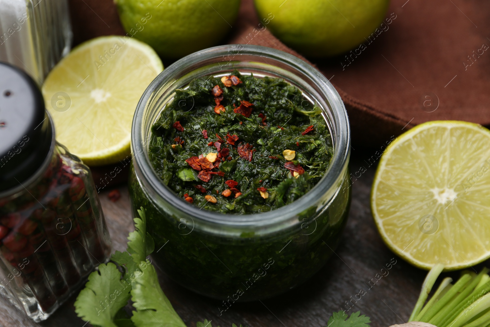 Tasty sauce with cilantro and limes on wooden table, closeup Photo of Tasty sauce with cilantro and limes on wooden table, closeup