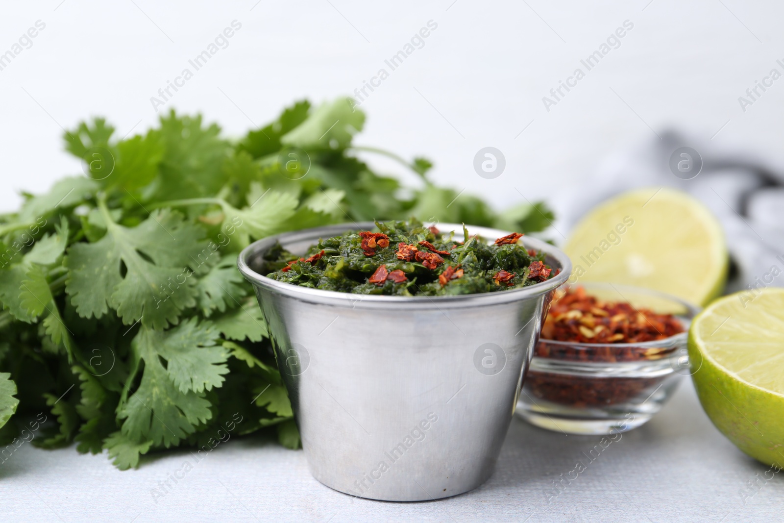Tasty sauce with cilantro and other ingredients on light table, closeup Photo of Tasty sauce with cilantro and other ingredients on light table, closeup