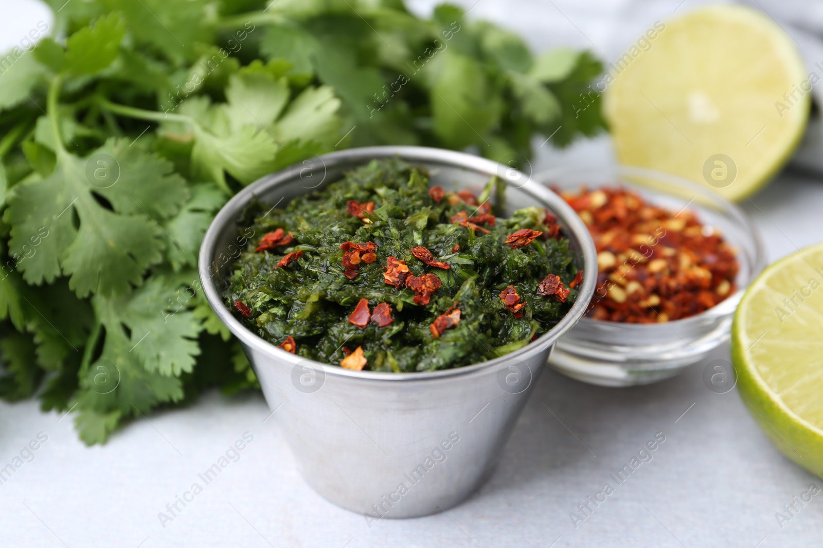 Tasty sauce with cilantro and other ingredients on light table, closeup Photo of Tasty sauce with cilantro and other ingredients on light table, closeup