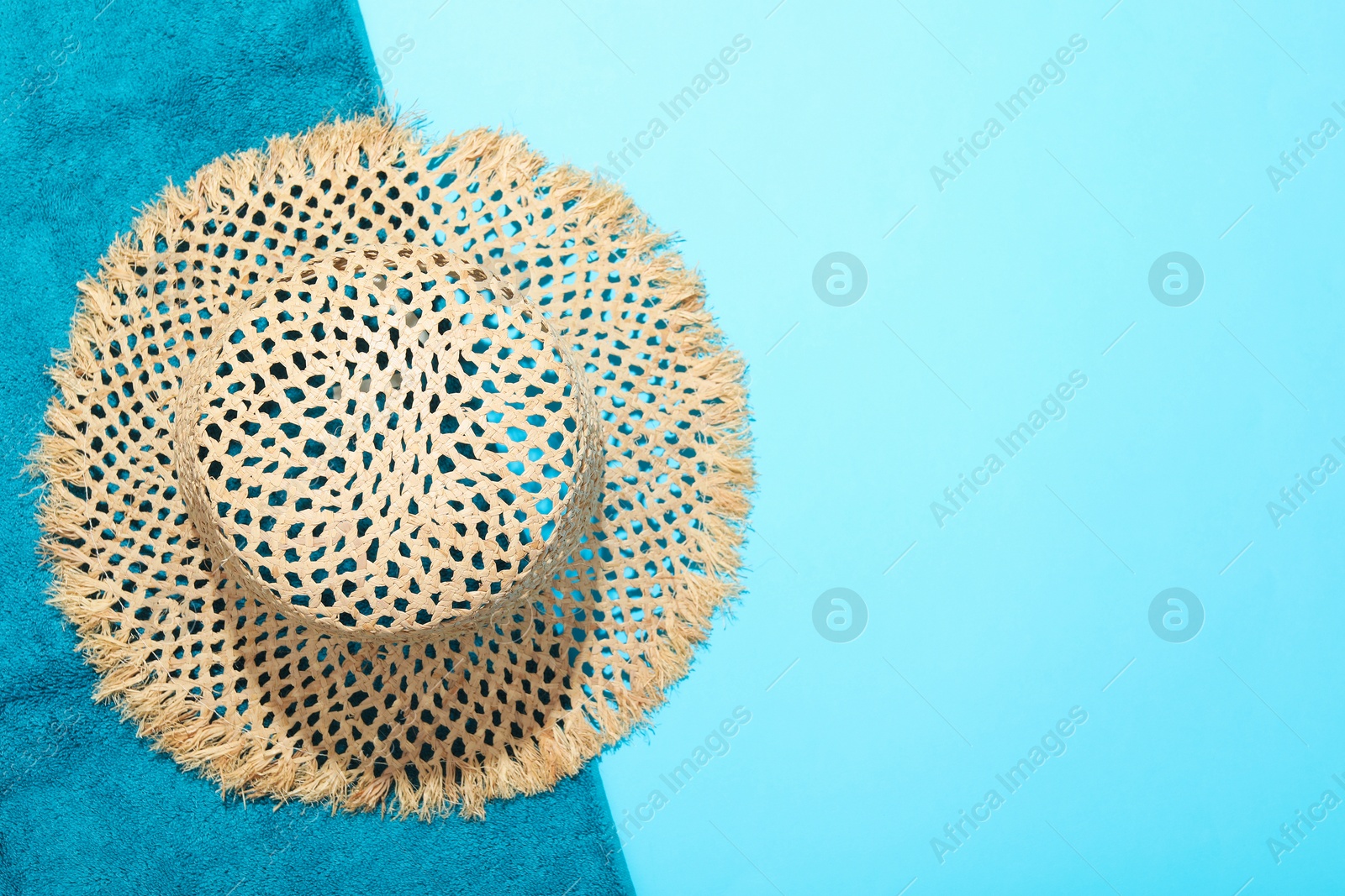 Straw hat and beach towel on light blue background, top view. Space for text Photo of Straw hat and beach towel on light blue background, top view. Space for text
