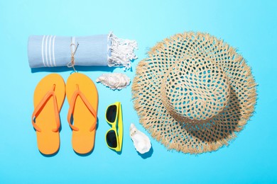 Photo of Flat lay composition with beach towel and other summer accessories on light blue background