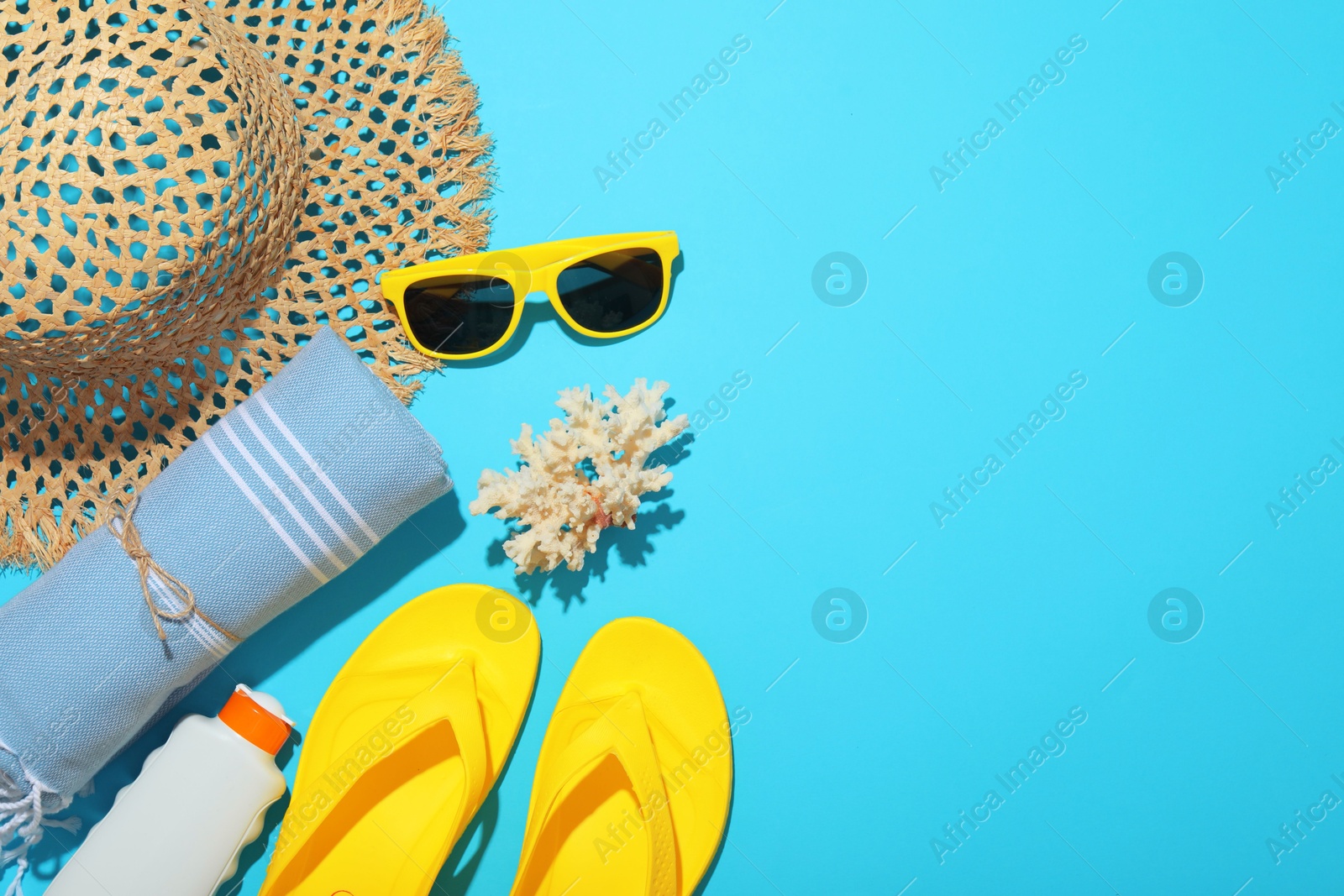 Flat lay composition with beach towel and other summer accessories on light blue background. Space for text Photo of Flat lay composition with beach towel and other summer accessories on light blue background. Space for text