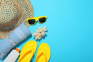 Photo of Flat lay composition with beach towel and other summer accessories on light blue background. Space for text
