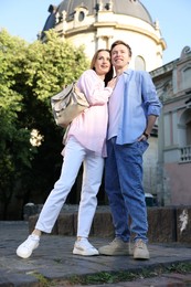 Photo of Lovely couple walking together on city street, low angle view
