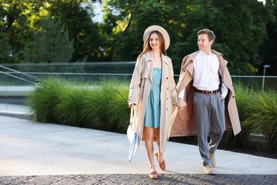 Photo of Lovely couple walking together on city street, space for text