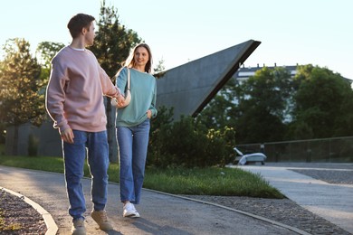 Photo of Lovely couple walking together in park, space for text