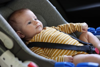 Photo of Cute little baby fastened in car seat