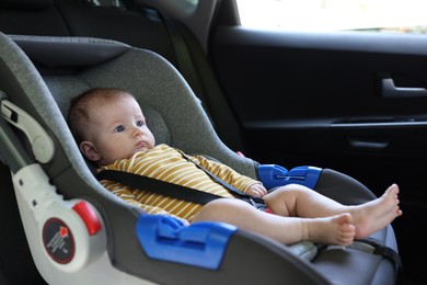 Photo of Cute little baby fastened in car seat