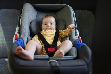 Photo of Cute little baby fastened in car seat