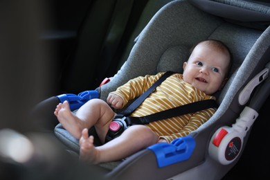 Photo of Cute little baby fastened in car seat