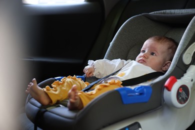 Photo of Cute little baby fastened in car seat
