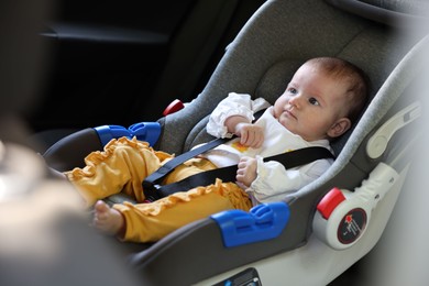 Photo of Cute little baby fastened in car seat
