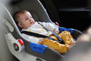 Photo of Cute little baby fastened in car seat