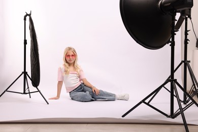 Photo of Little girl on white background in photo studio with professional equipment