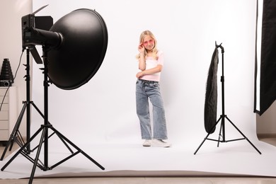 Photo of Little girl on white background in photo studio with professional equipment