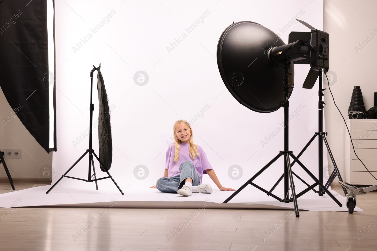 Photo of Little girl on white background in photo studio with professional equipment