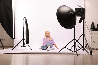 Photo of Little girl on white background in photo studio with professional equipment