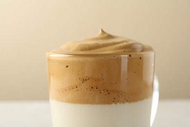 Photo of Delicious dalgona coffee in glass cup on blurred background, closeup