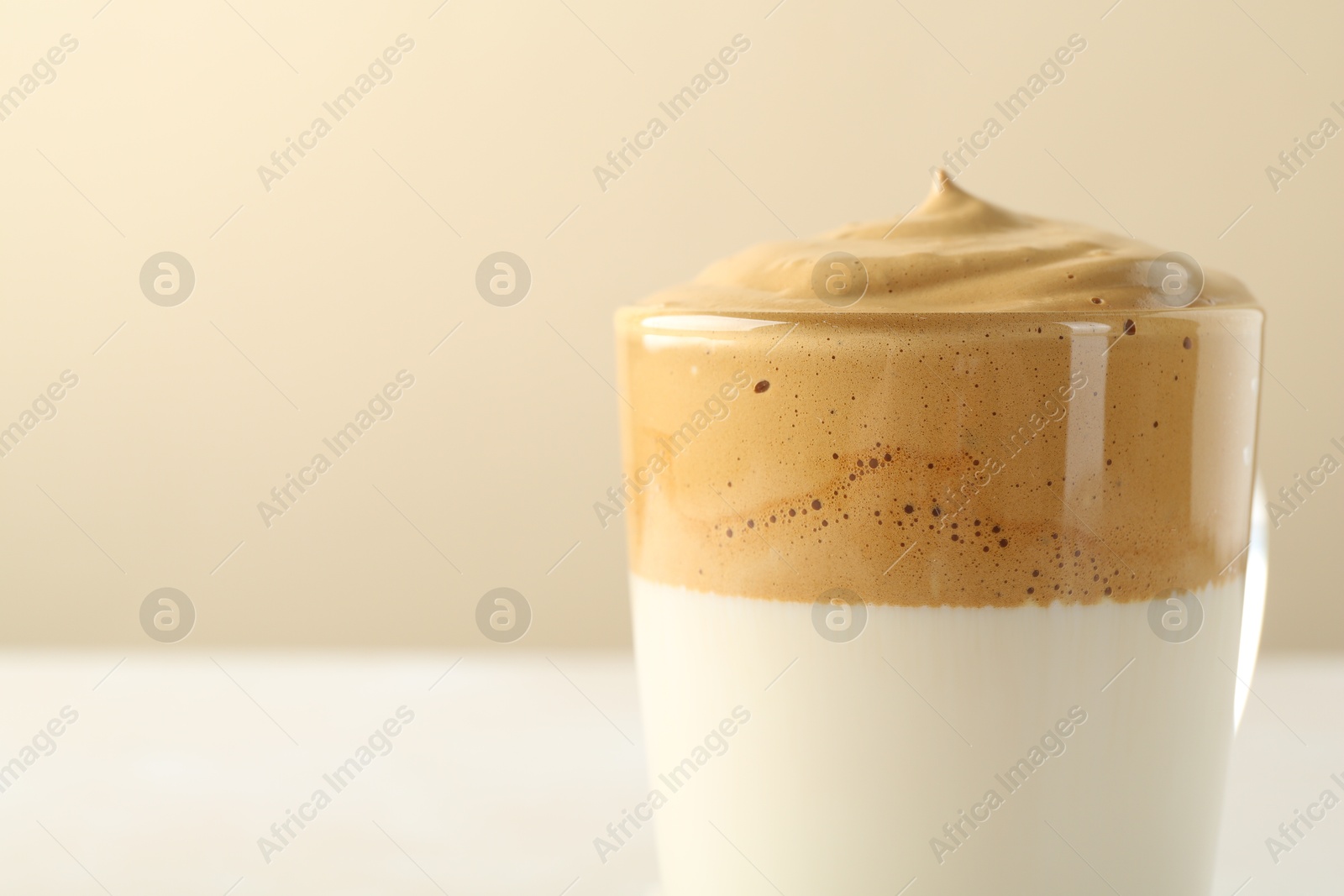 Delicious dalgona coffee in glass cup on blurred background, closeup. Space for text Photo of Delicious dalgona coffee in glass cup on blurred background, closeup. Space for text