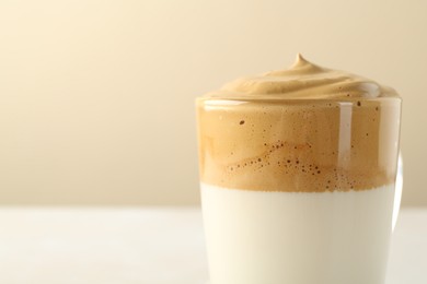 Photo of Delicious dalgona coffee in glass cup on blurred background, closeup. Space for text