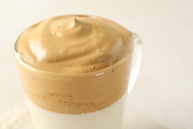 Photo of Delicious dalgona coffee in glass cup on light background, closeup