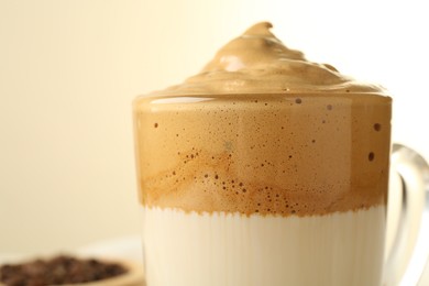 Photo of Delicious dalgona coffee in glass cup on blurred background, closeup