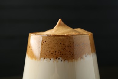 Photo of Delicious dalgona coffee in glass on blurred background, closeup