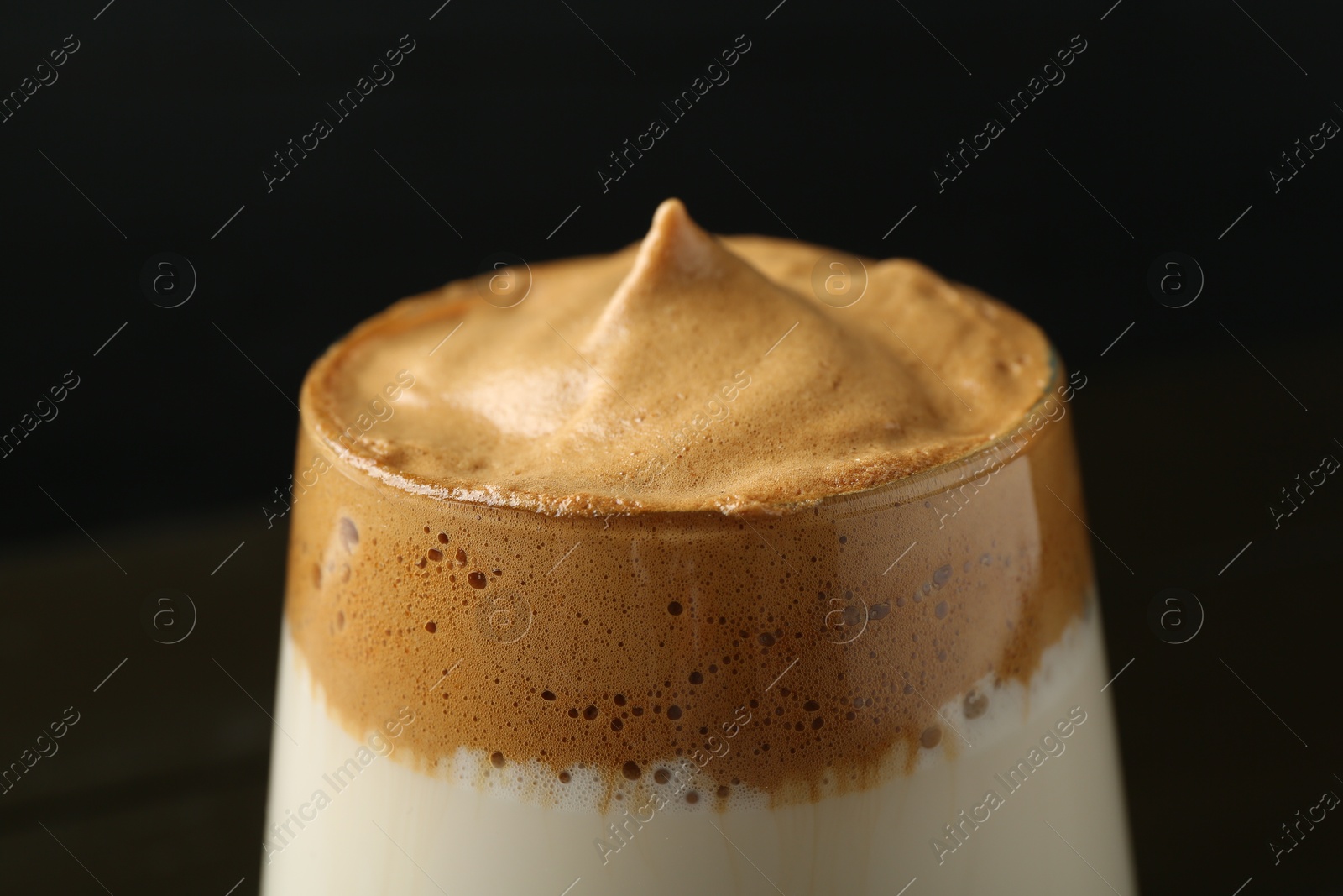 Photo of Delicious dalgona coffee in glass on blurred background, closeup