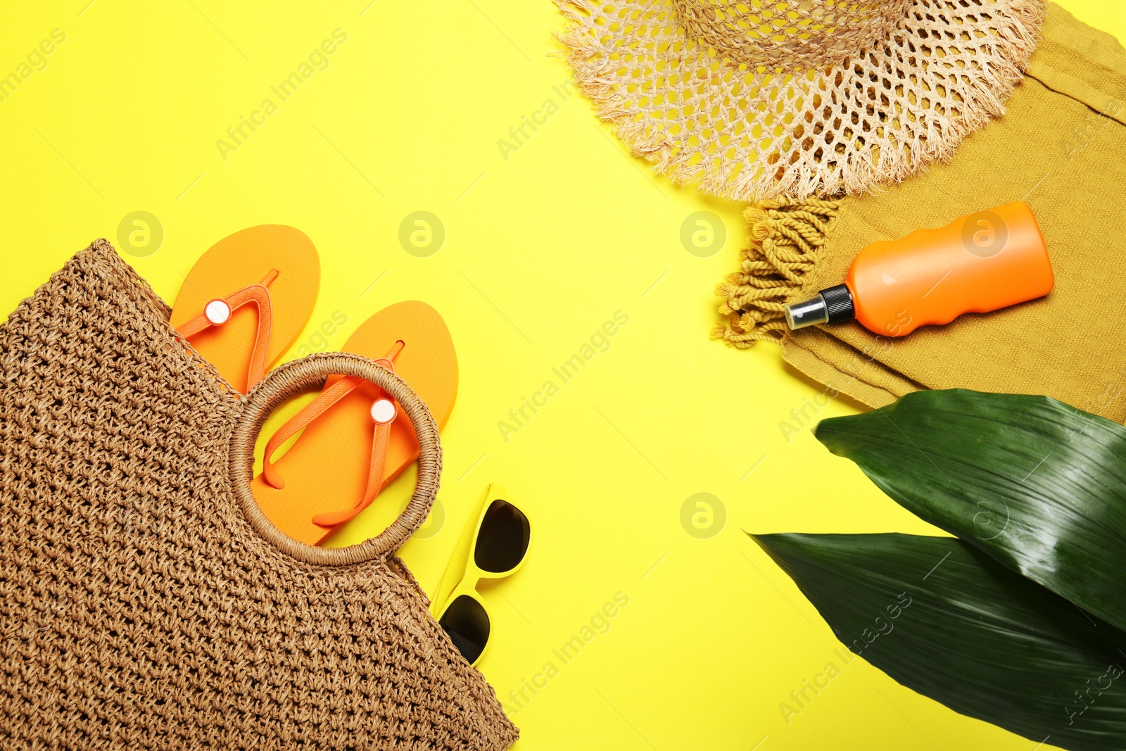 Flat lay composition with beach towel and other summer accessories on yellow background Photo of Flat lay composition with beach towel and other summer accessories on yellow background